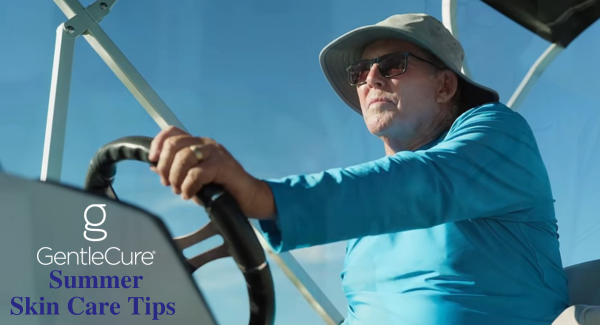A person wearing a sun hat and sunglasses is steering a boat. The sky is clear. The text reads, "GentleCure® Summer Skin Care Tips."