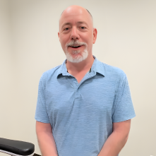 Smiling man standing next to GentleCure treatment chair